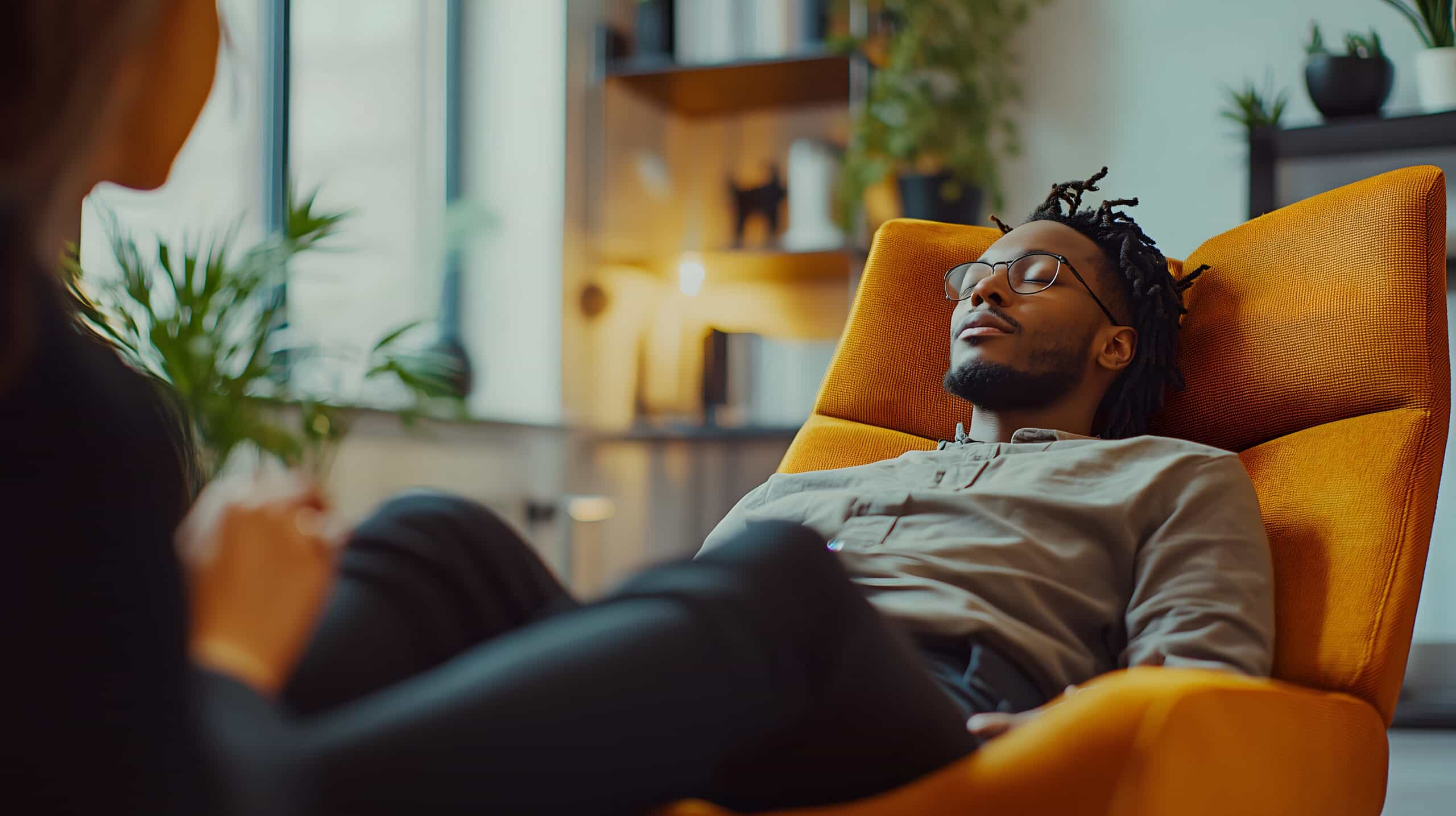 Young man undergoing a modern hypnotherapy session in a futuristic laboratory setting, supervised by a specialist in a cozy environment.